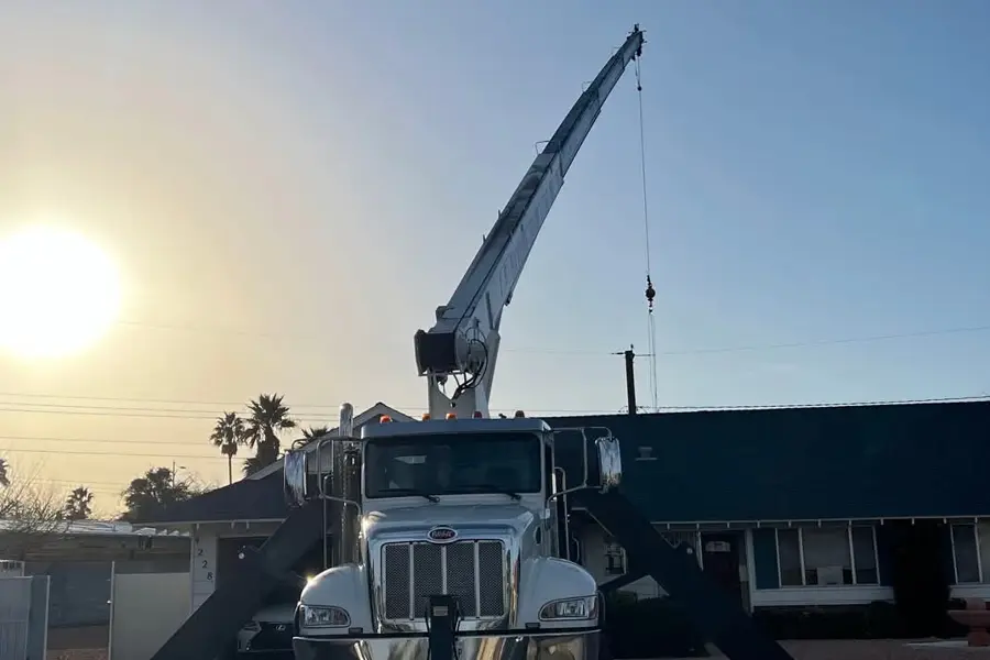 Crane truck setting up for a rooftop HVAC replacement