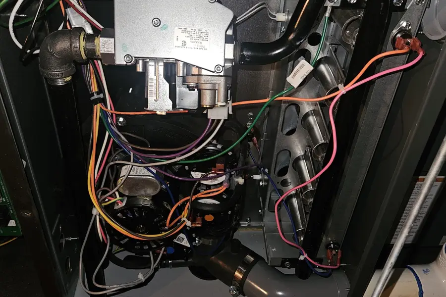Inside a gas furnace showing the gas valve and wiring