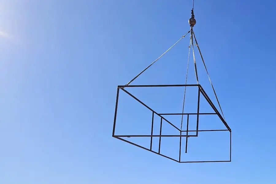 Steel HVAC curb frame lifted by crane above a Las Vegas neighborhood